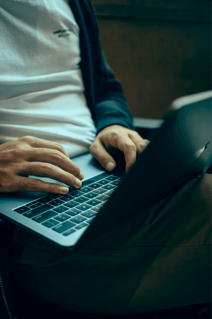 Hands typing on a laptop keyboard